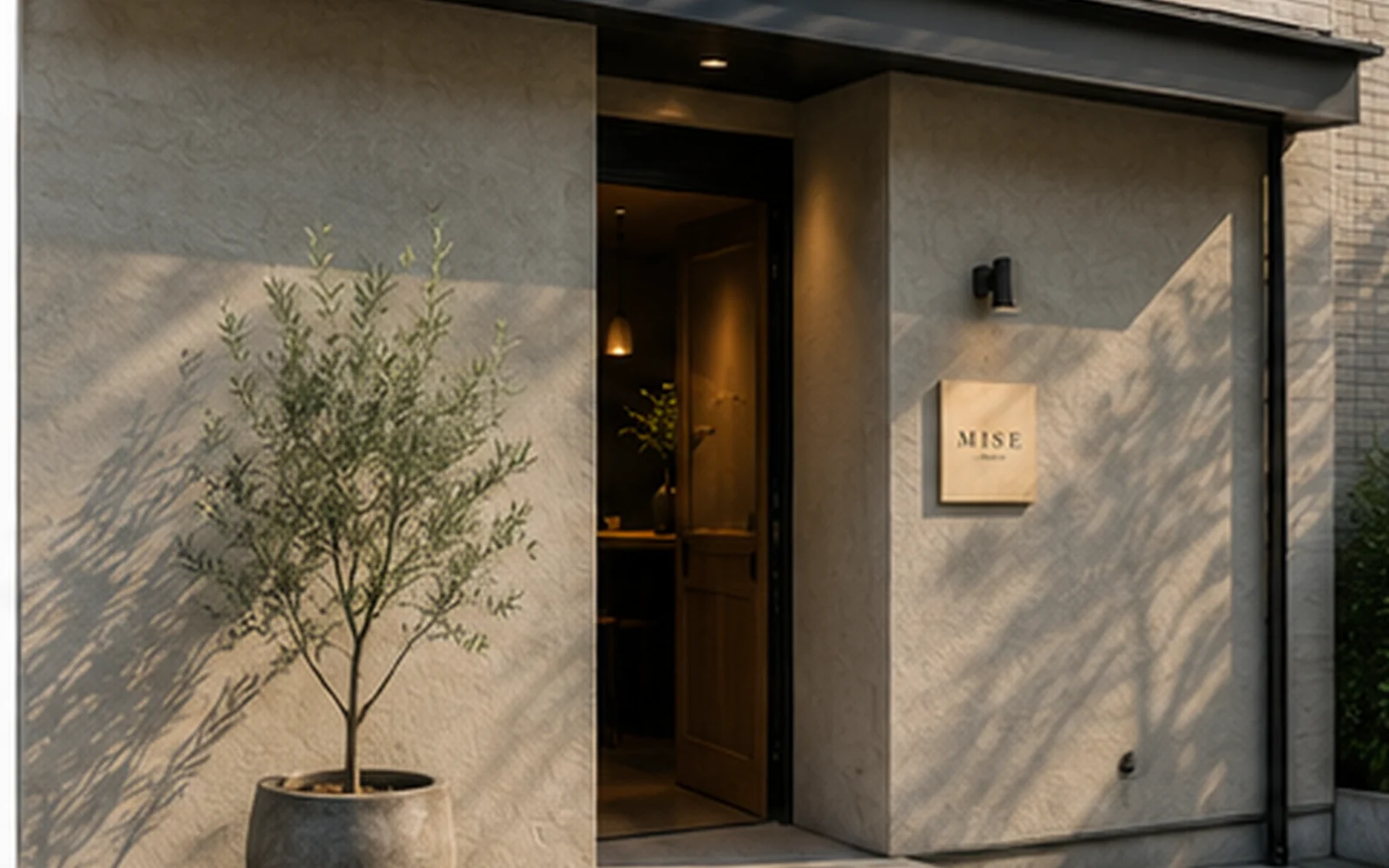 夜の店の入口。開いた扉から灯りが漏れている。